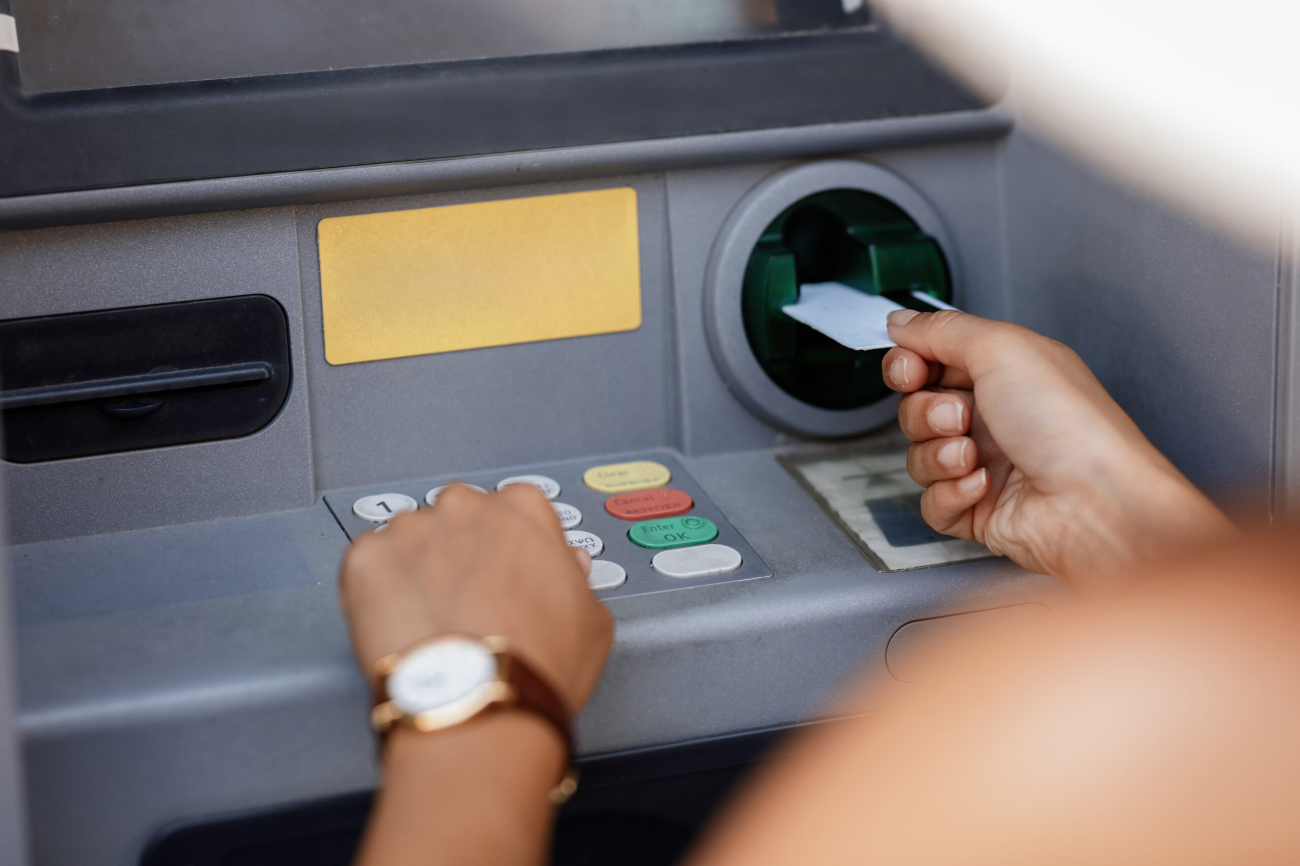 closeup woman typing pin code while withdrawing money from atm scaled.jpg
