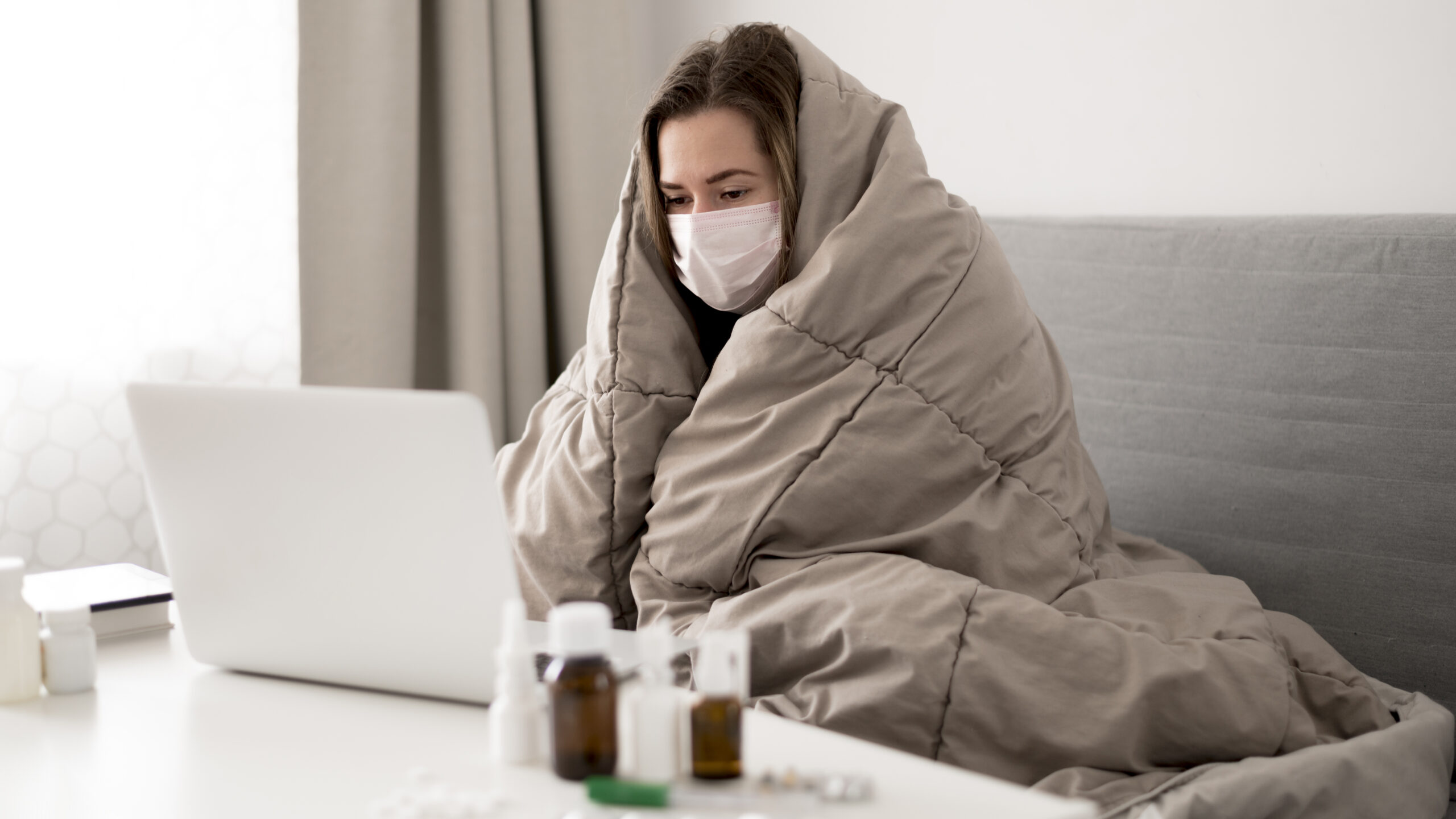 Woman wearing medical mask wrapped blanket scaled.jpg